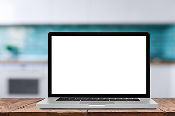 Image showing Laptop with blank screen against blurred kitchen interior background.