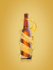 Image showing Beer bottle with water drops and spiral splash around bottle.