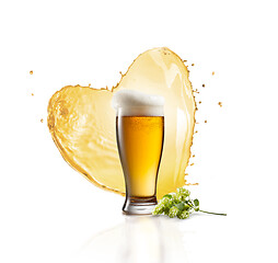 Image showing Glass of fresh beer with splash in the shape of heart and hop banch.