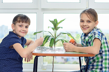 Image showing Children assemble a puzzle at home and happily look into the frame