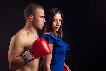 Image showing Boxer hugs slender girl on black background