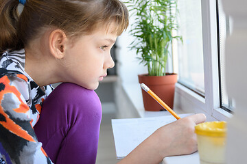 Image showing The girl draws thoughtfully and looked out the window