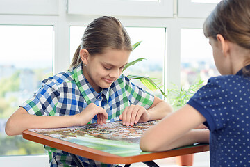 Image showing Two children play a board game and collect puzzles