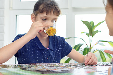 Image showing Girl drinks water playing board games at the table