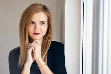 Image showing Portrait of a young beautiful girl near a window with natural lighting