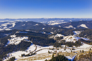 Image showing Aerial winter landscape of forests and a curvy road