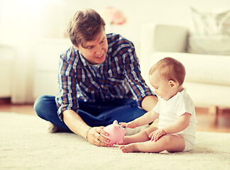 Image showing happy father with baby and piggy bank at home