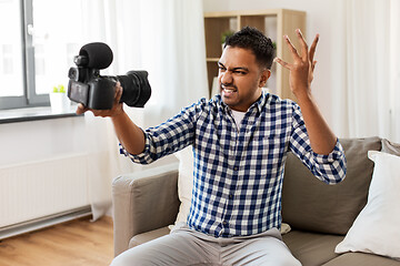 Image showing male video blogger with camera blogging at home