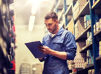 Image showing auto mechanic with clipboard at car workshop