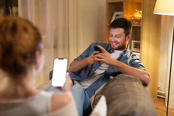 Image showing couple with smartphones at home in evening