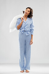 Image showing happy woman in blue pajama holding pillow