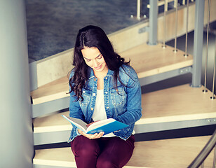 Image showing high school student girl reading book on stairs