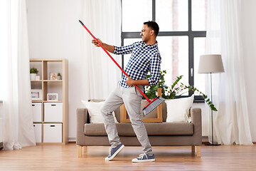 Image showing man with broom cleaning and having fun at home