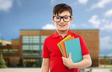 Image showing smiling schoolboy in glasses with books