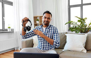 Image showing male blogger with headphones videoblogging at home