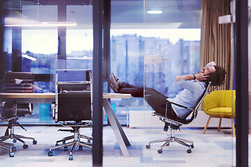 Image showing young businessman relaxing at the desk