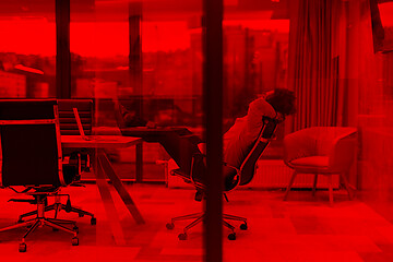 Image showing young businessman relaxing at the desk