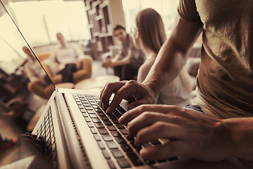 Image showing close up of male hands while working on laptop