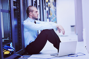 Image showing businessman with laptop in network server room