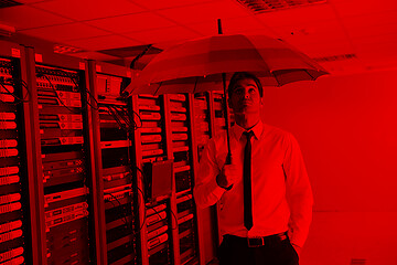 Image showing businessman hold umbrella in server room