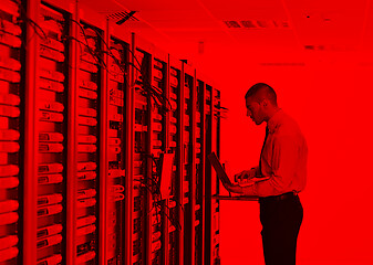 Image showing businessman with laptop in network server room