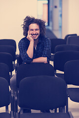 Image showing A student sits alone  in a classroom