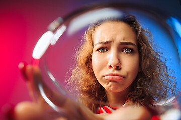 Image showing The surprised young woman in party clothes posing with glass of wine.