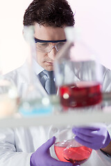 Image showing Chemist in chemical laoratory searching for the right solution.