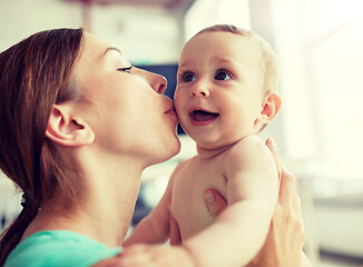 Image showing happy young mother kissing little baby at home