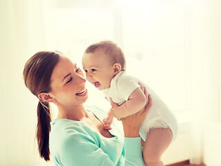 Image showing happy young mother with little baby at home