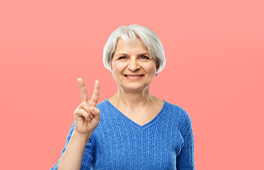 Image showing portrait of smiling senior woman showing peace