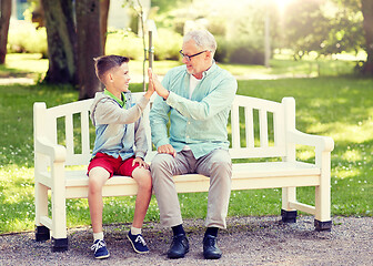 Image showing old man and boy making high five at summer park