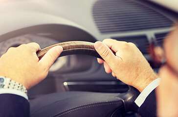 Image showing senior businessman hands driving car