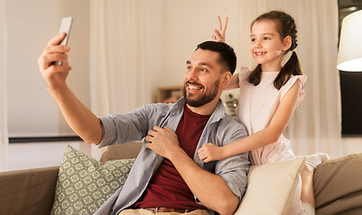 Image showing father and daughter taking selfie at home