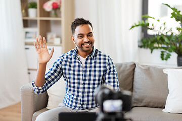 Image showing male blogger with camera videoblogging at home