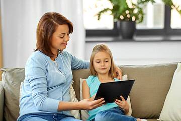 Image showing happy mother and daughter with tablet pc at home