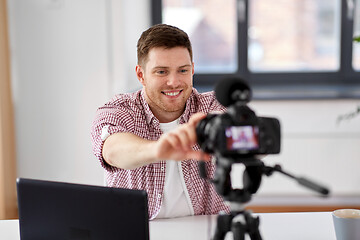 Image showing male video blogger adjusting camera at home office