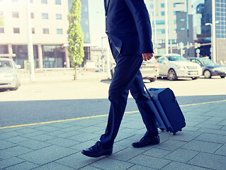 Image showing senior businessman walking with travel bag in city