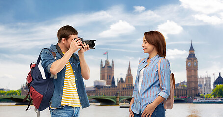 Image showing happy couple of tourists with backpacks and camera