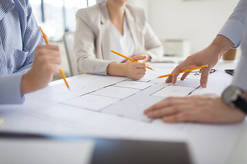 Image showing close up of architects with blueprint at office