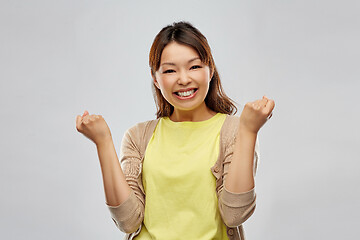 Image showing happy asian woman celebrating success