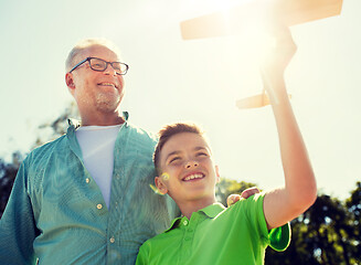 Image showing senior man and boy with toy airplane over sky