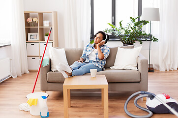 Image showing woman in headphones resting after home cleaning