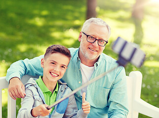 Image showing old man and boy taking selfie by smartphone