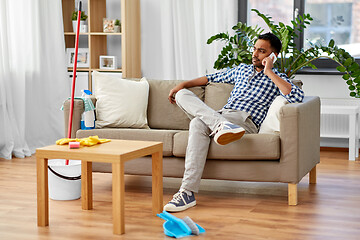 Image showing man calling on smartphone after cleaning home