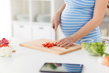 Image showing close up of pregnant woman cooking food at home