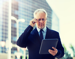 Image showing senior businessman with tablet pc on city street