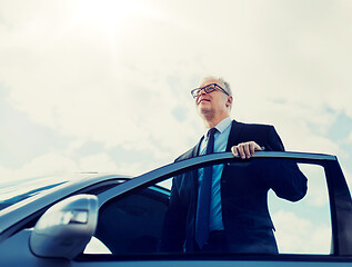 Image showing senior businessman getting into car