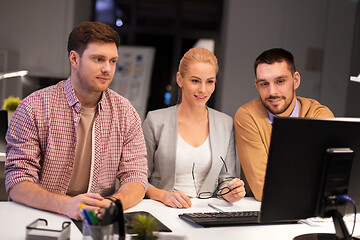 Image showing business team with computer working late at office