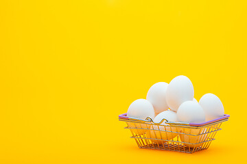 Image showing Grocery basket with chicken eggs on an orange background